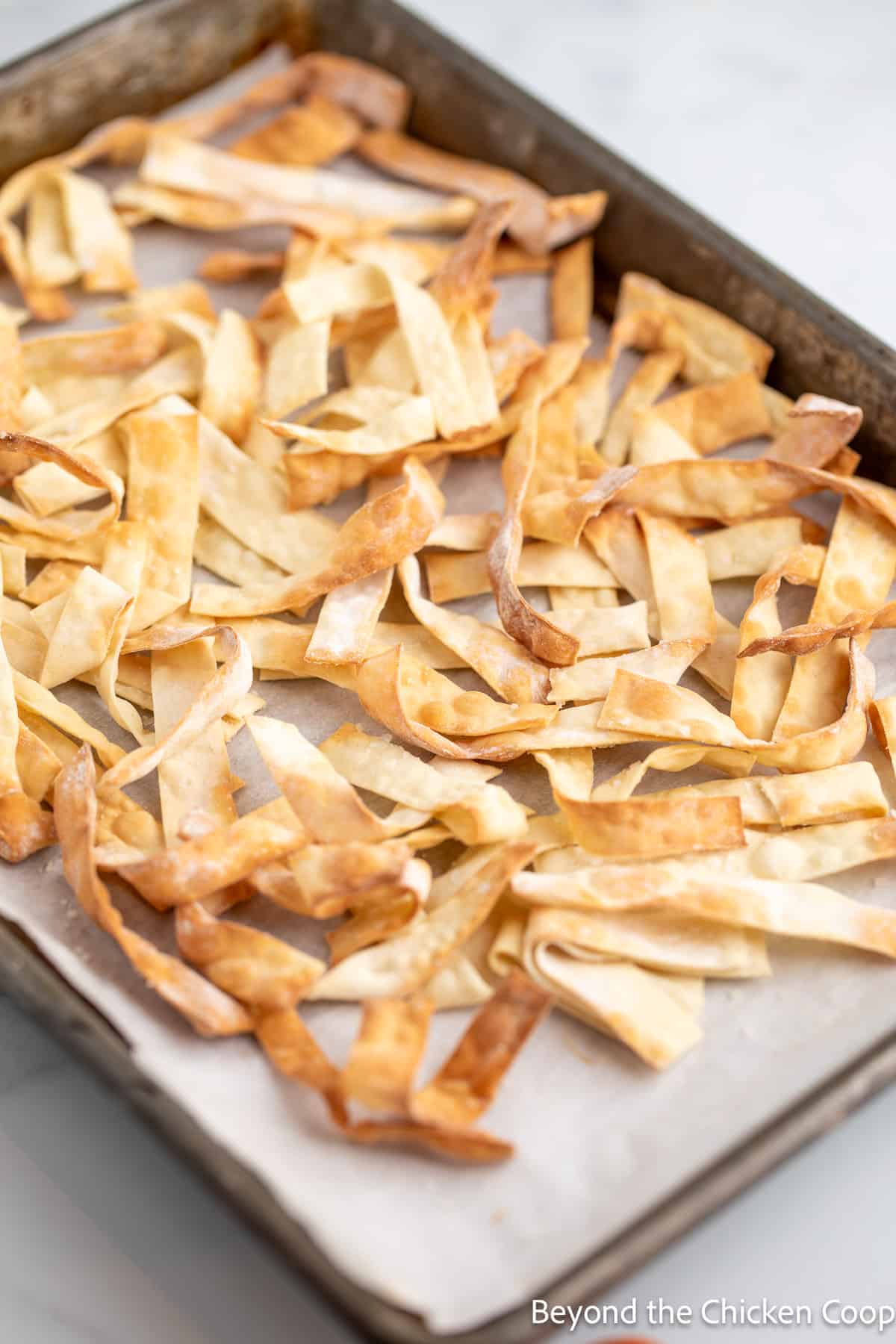 Crispy wonton wrappers on a baking sheet. 