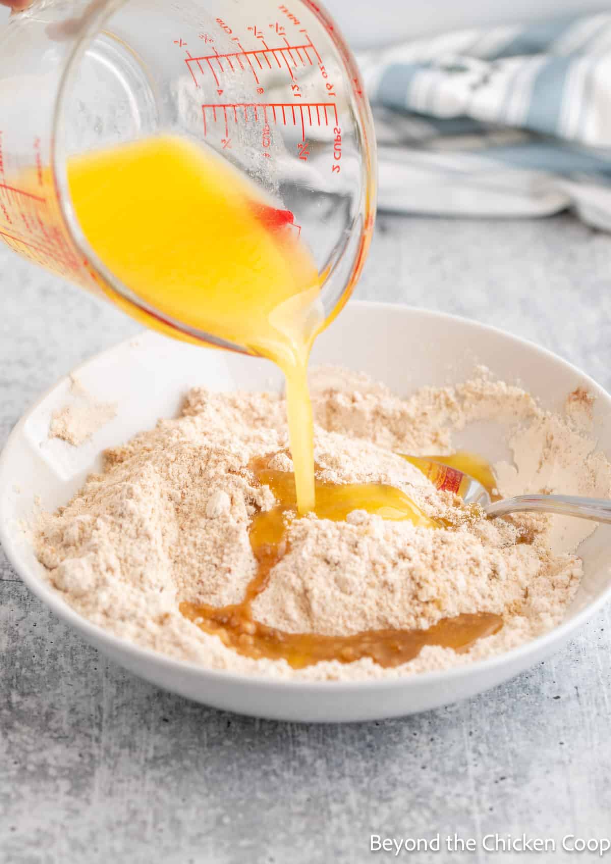 Pouring melted butter into a bowl with flour. 