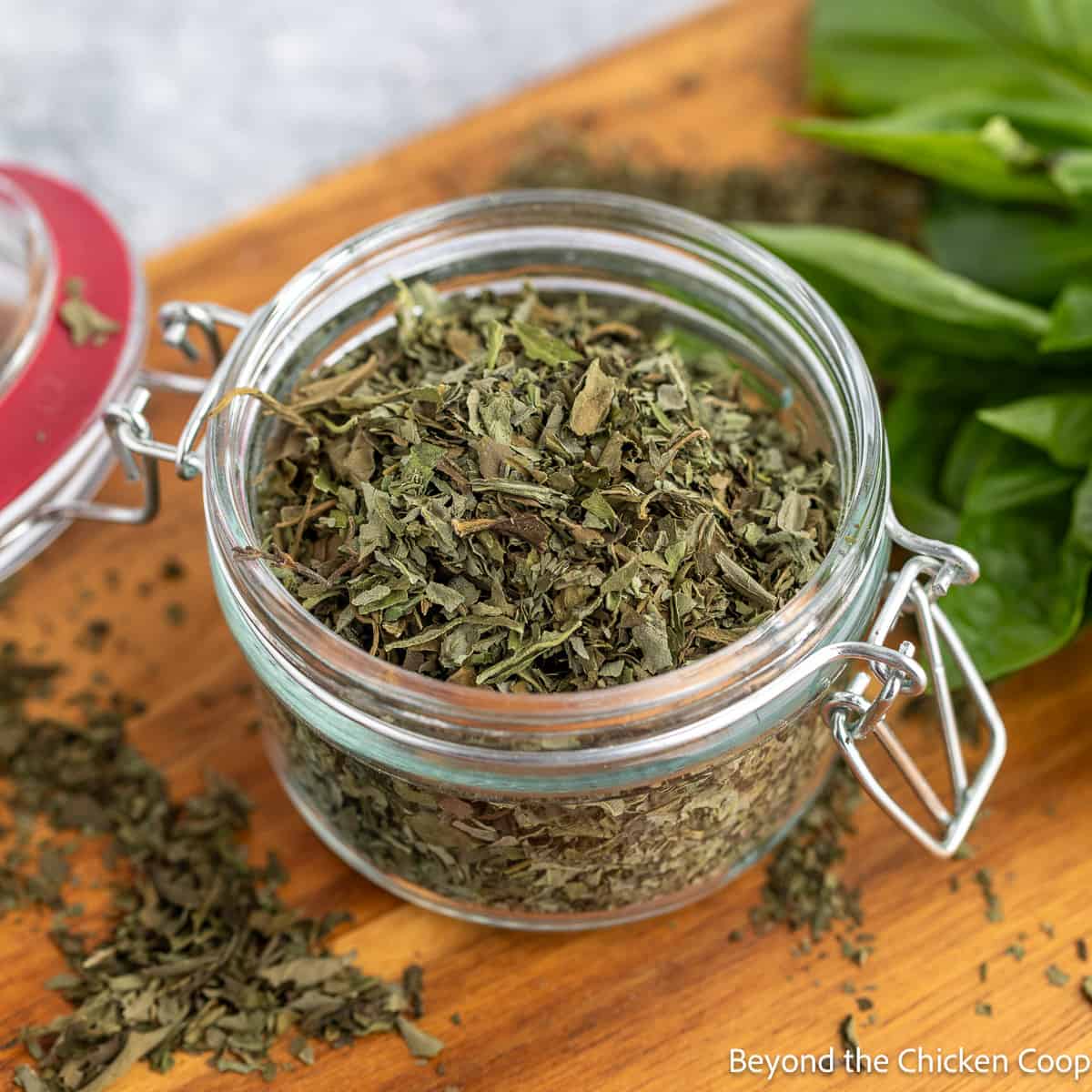 A glass jar filled with dried herbs.