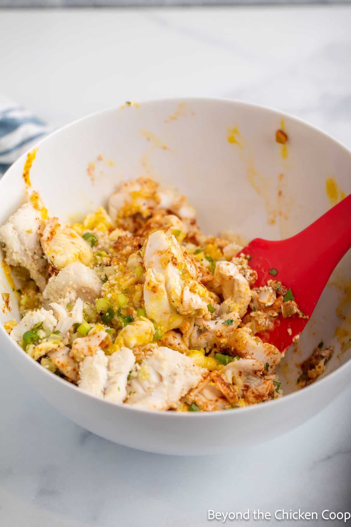 Stirring up ingredients in a white bowl.