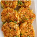 A platter filled with fish cakes and lemon wedges.