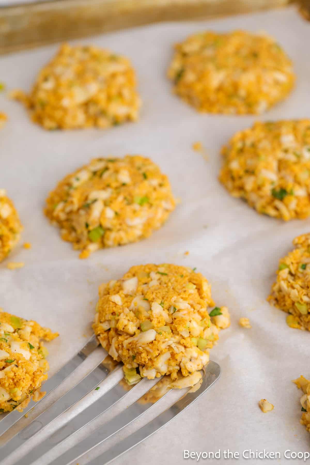 Uncooked fish patties on a baking sheet. 