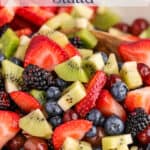 Berries, kiwi and grapes in a white bowl.