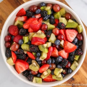 A bowl filled with berries, kiwi, and grapes.