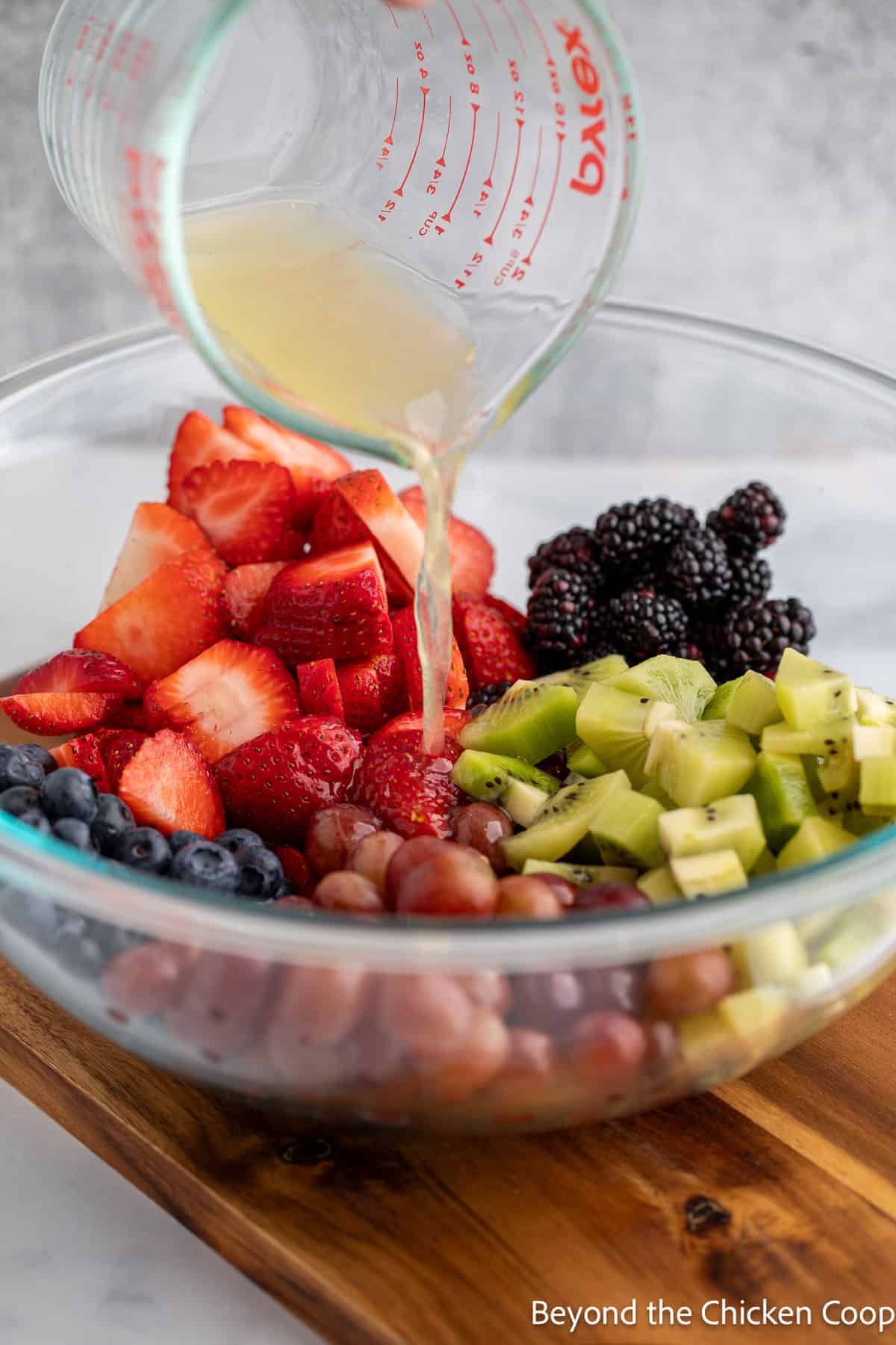 Pouring lemon juice over fresh fruit. 