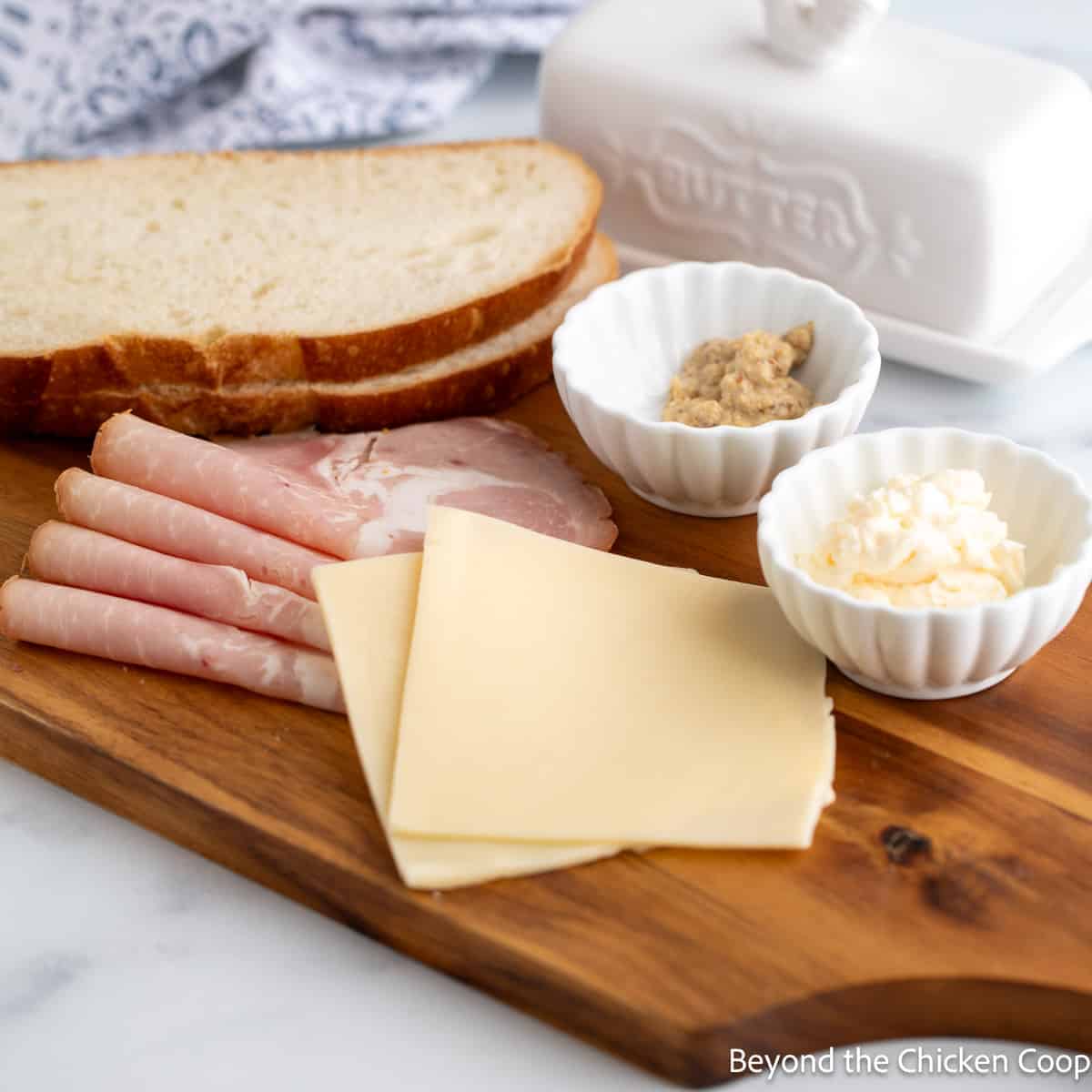 Slices of ham and cheese on a wooden board. 