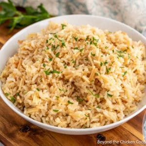 A bowl of rice topped with chopped parsley.