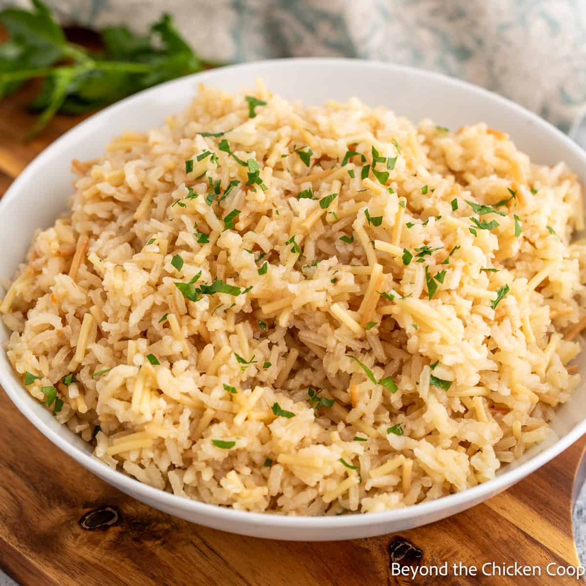 A bowl of rice topped with chopped parsley. 