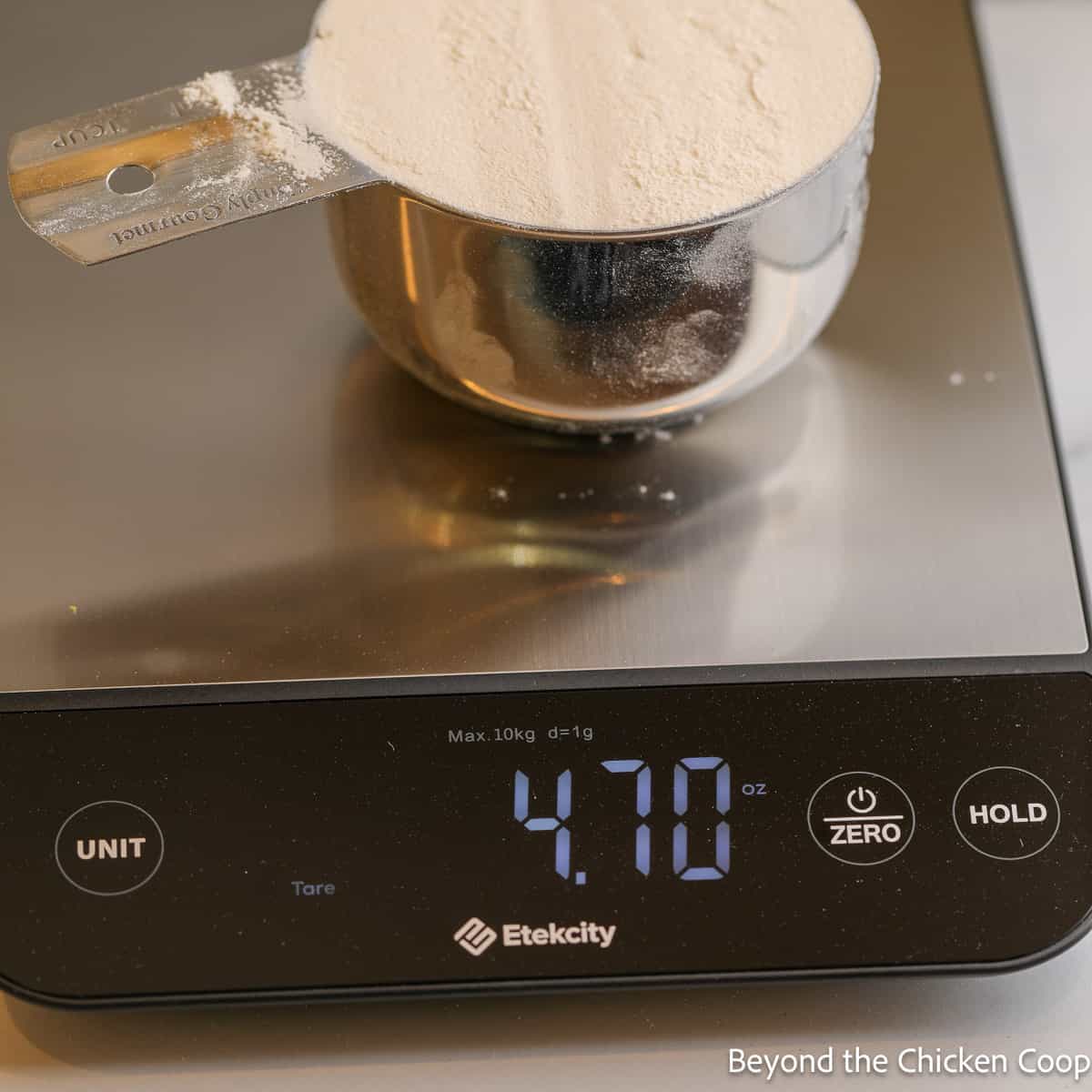 Measuring flour in a measuring cup with a digital scale. 