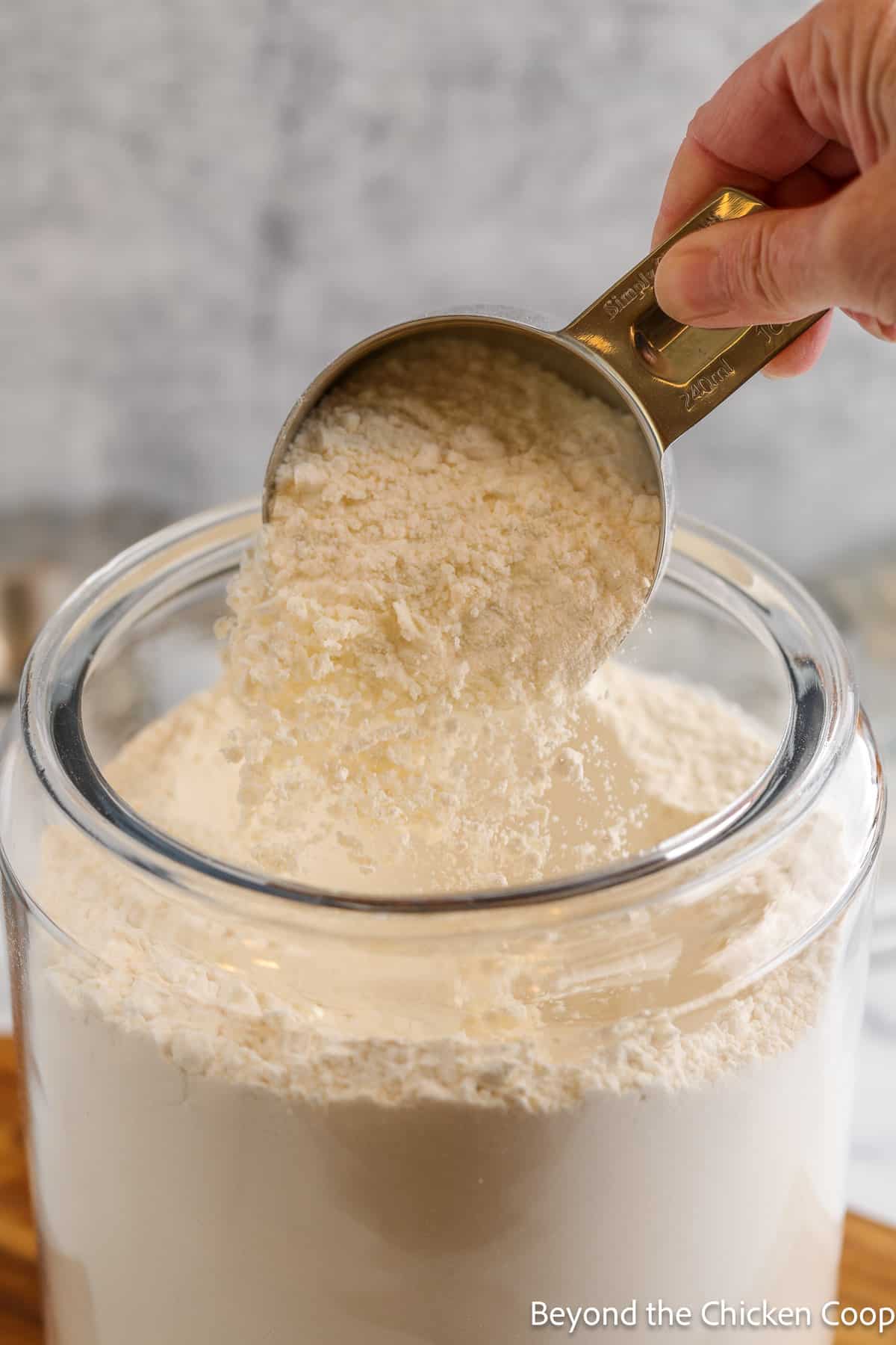 Fluffing flour in a container with a scoop.