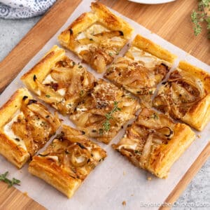 Puff pastry onion tart on a wooden board.