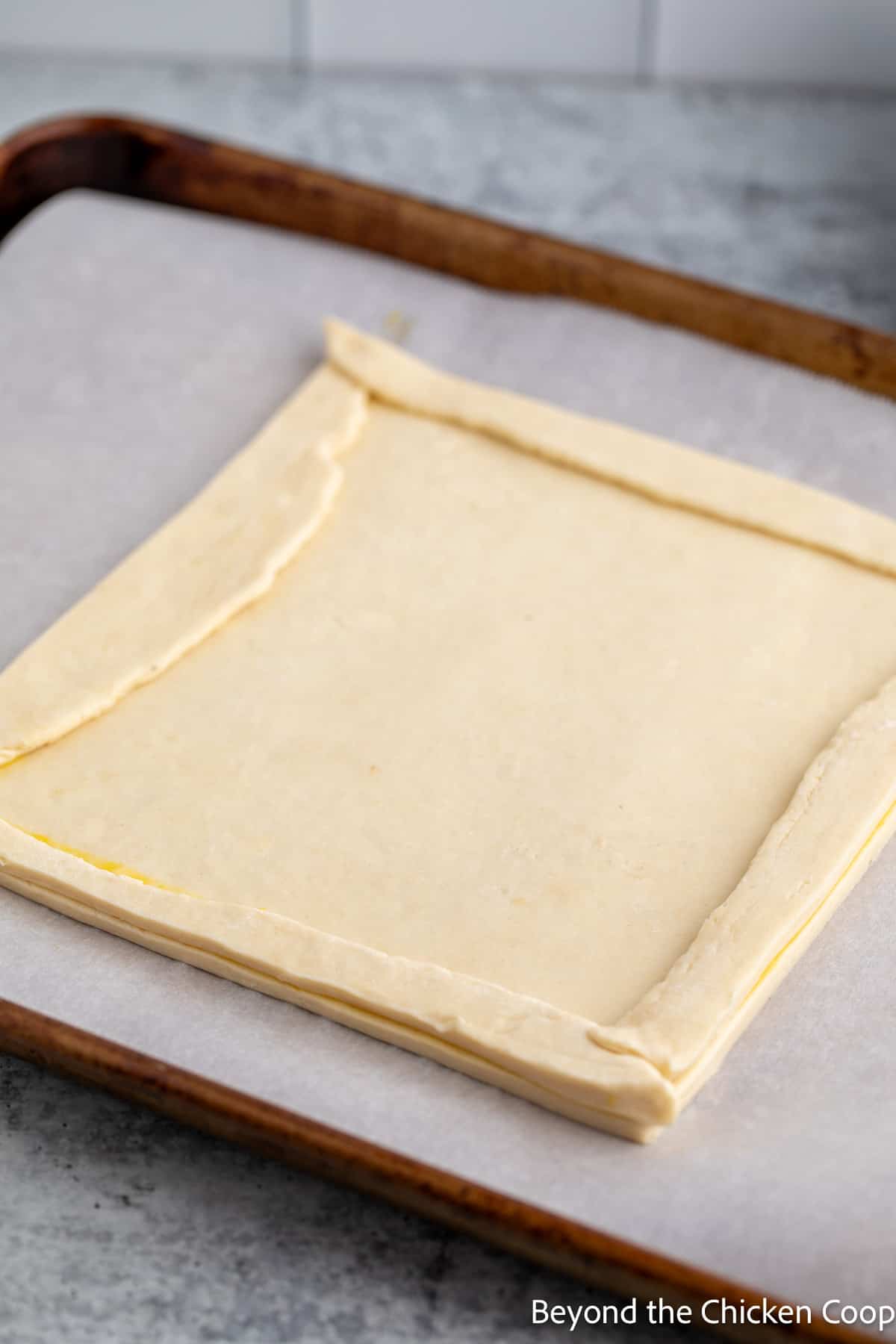 Puff pastry dough on a baking sheet.
