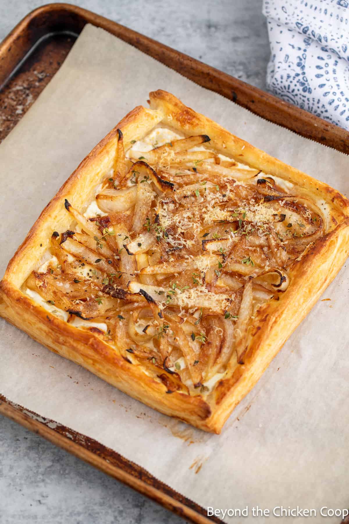 A baked onion tart on a cookie sheet. 