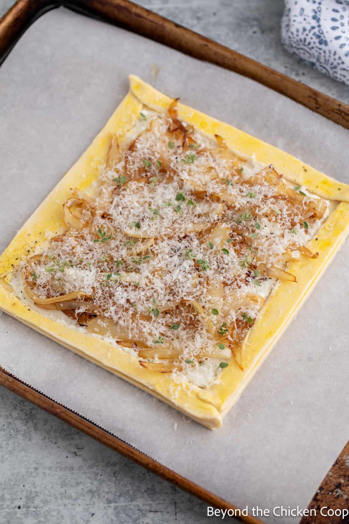 An onion tart on a baking sheet. 