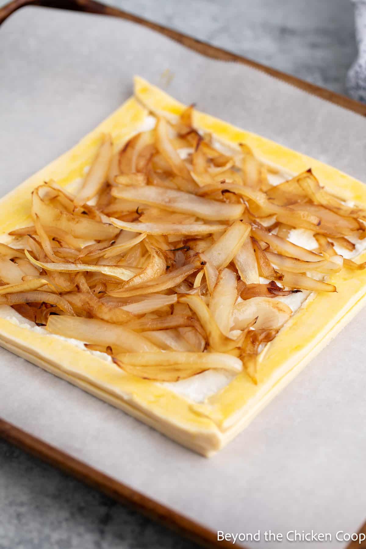Cooked onion on top of puff pastry dough. 