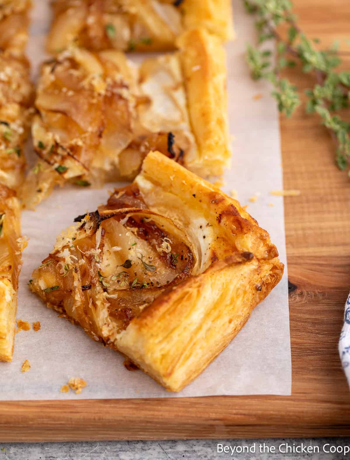 A slice of onion tart on a wooden board.