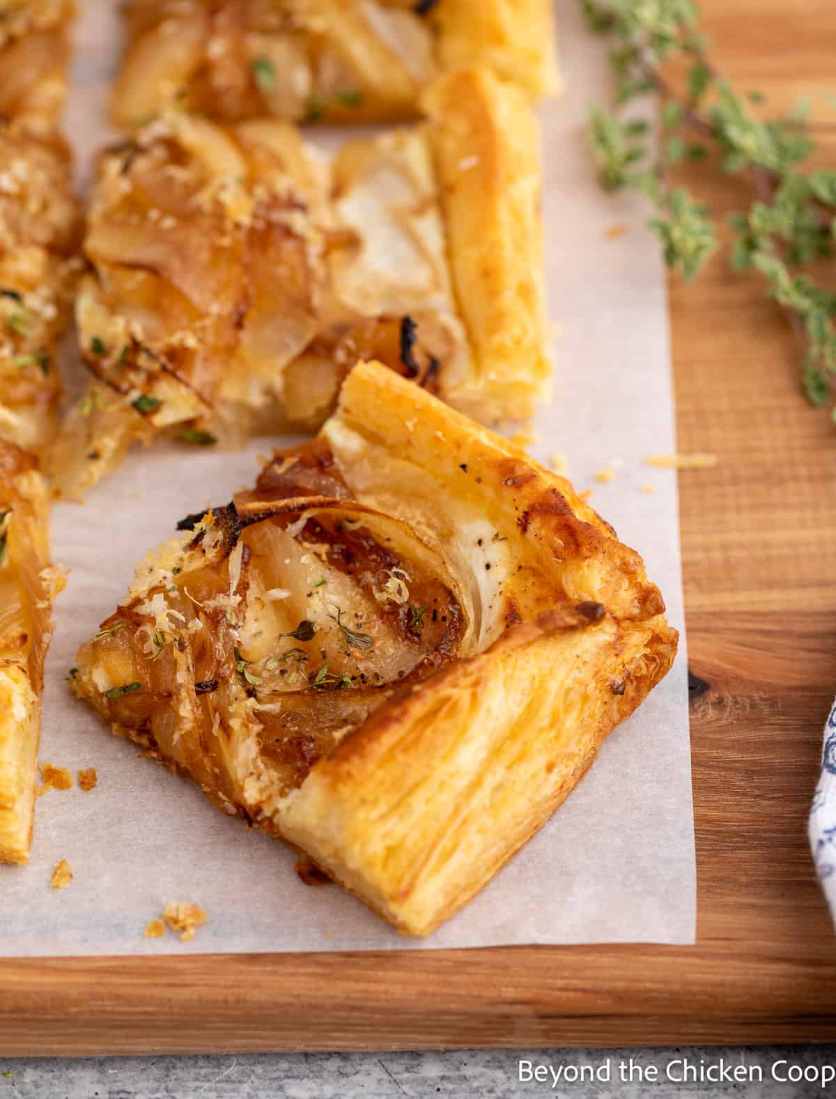 A slice of onion tart on a wooden board. 