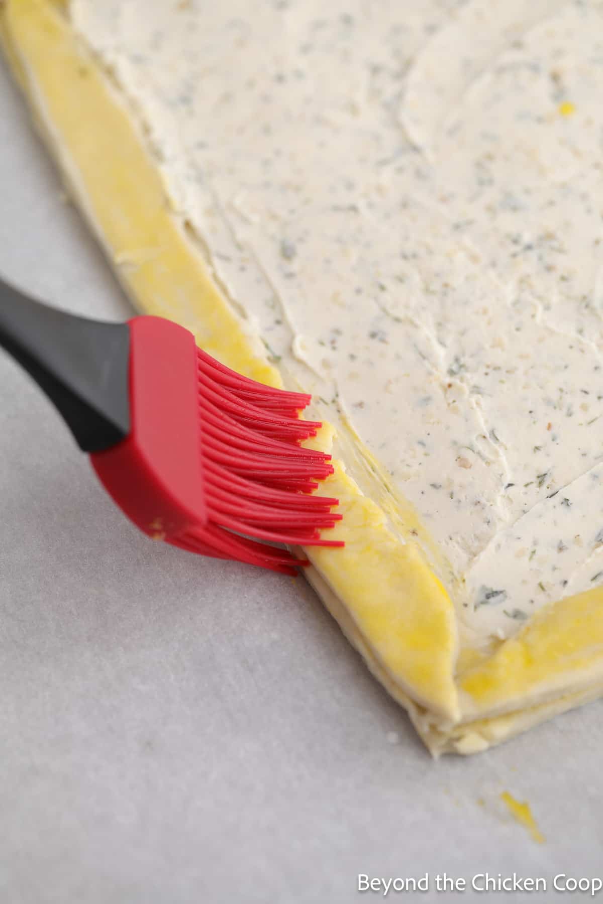 Brushing egg wash onto puff pastry. 