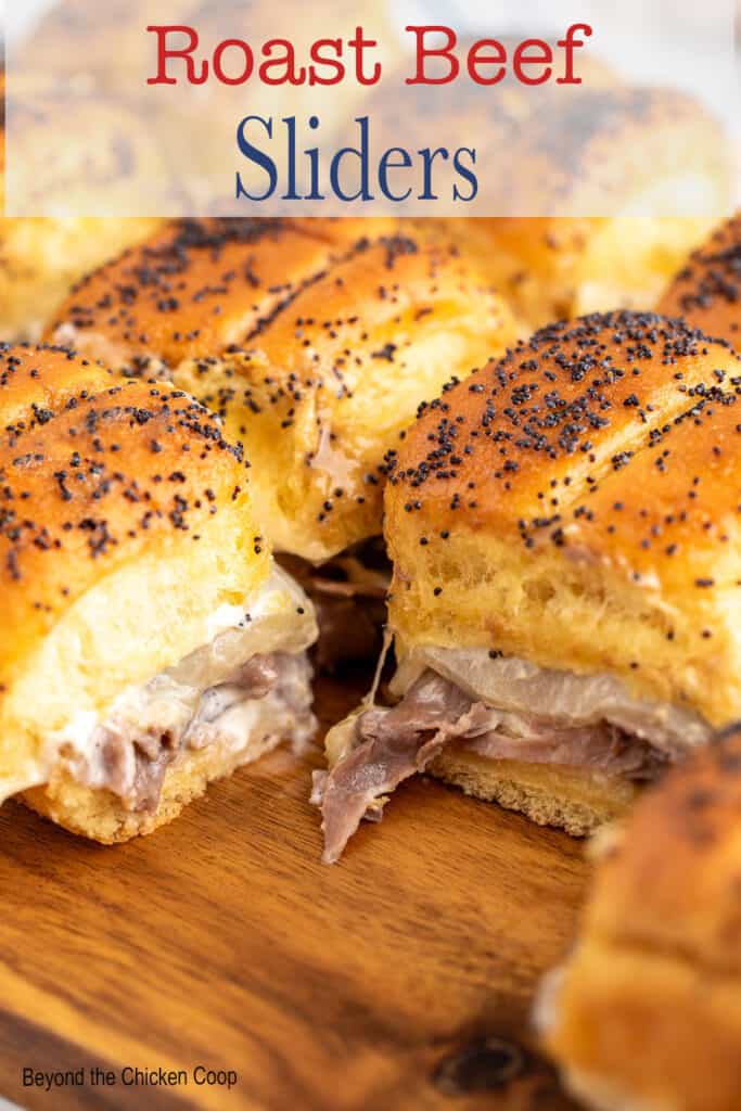 Small beef sandwiches on a wooden board.