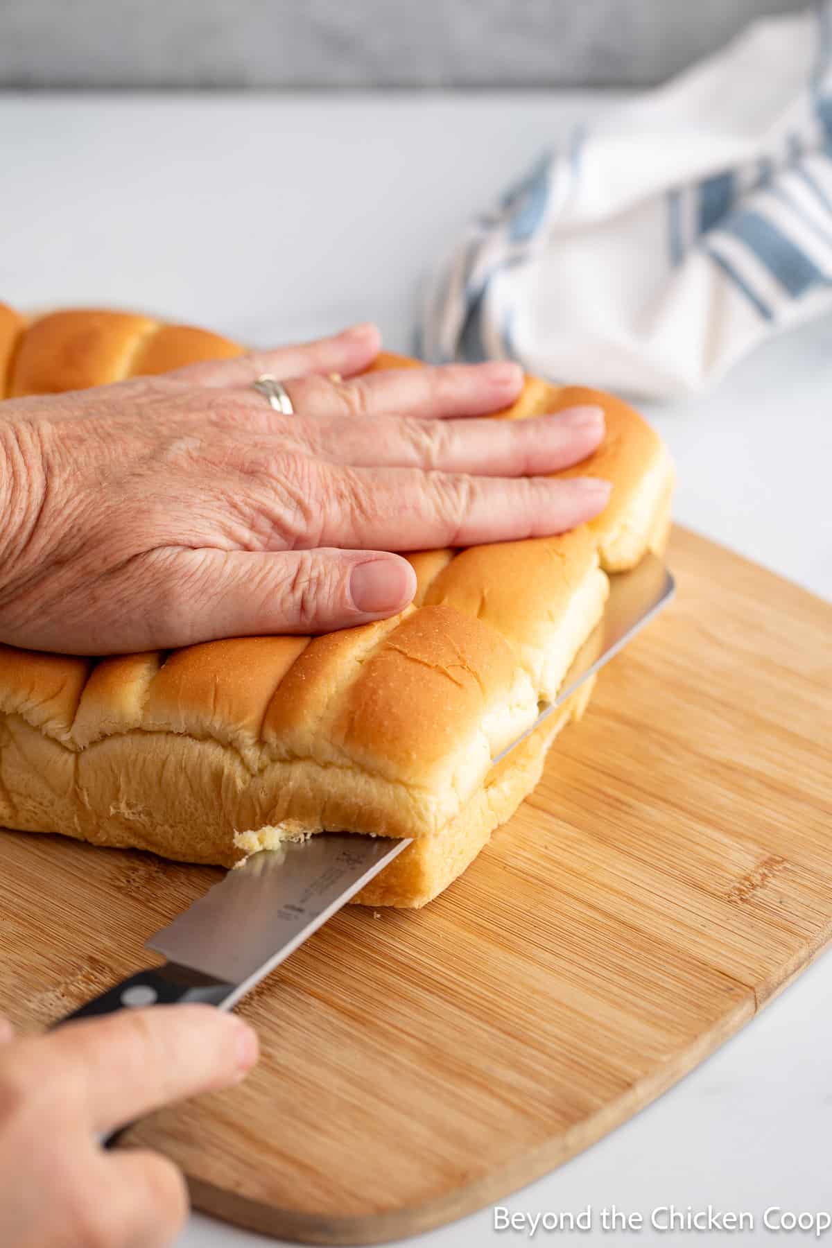 Slicing small buns in half. 