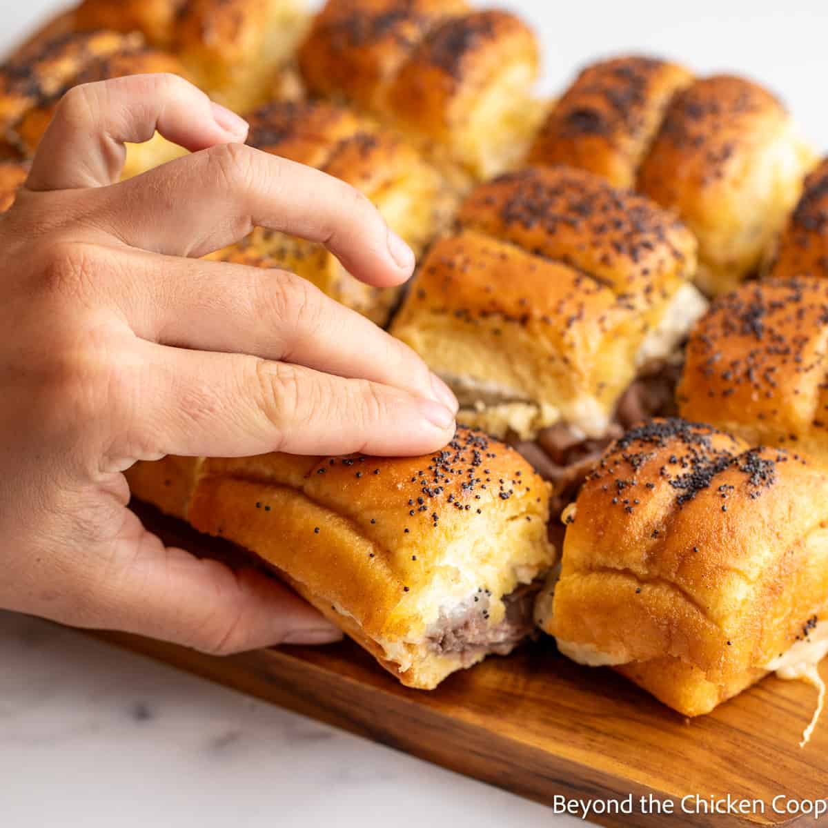 Grabbing a roll filled with roast beef. 