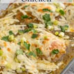 A casserole dish with chicken breasts topped with a green sauce and cheese.