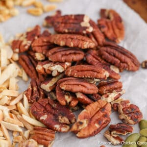 Toasted pecans next to other toasted nuts.