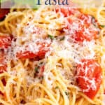 Pasta with cherry tomatoes topped with cheese.