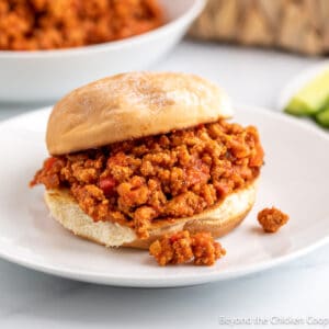 A sloppy joe sandwich on a white plate.