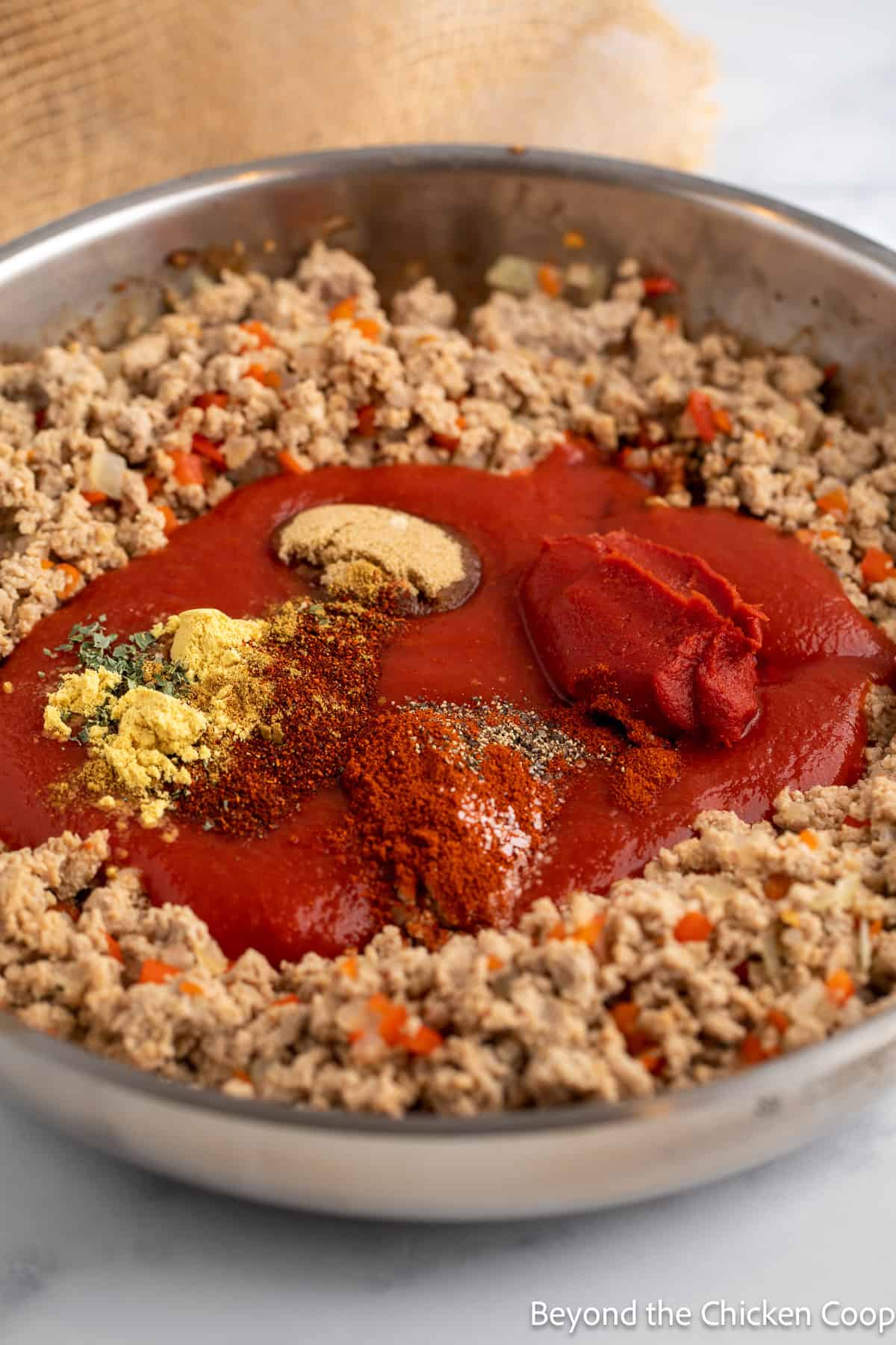Making a sauce in a pan with ground turkey. 