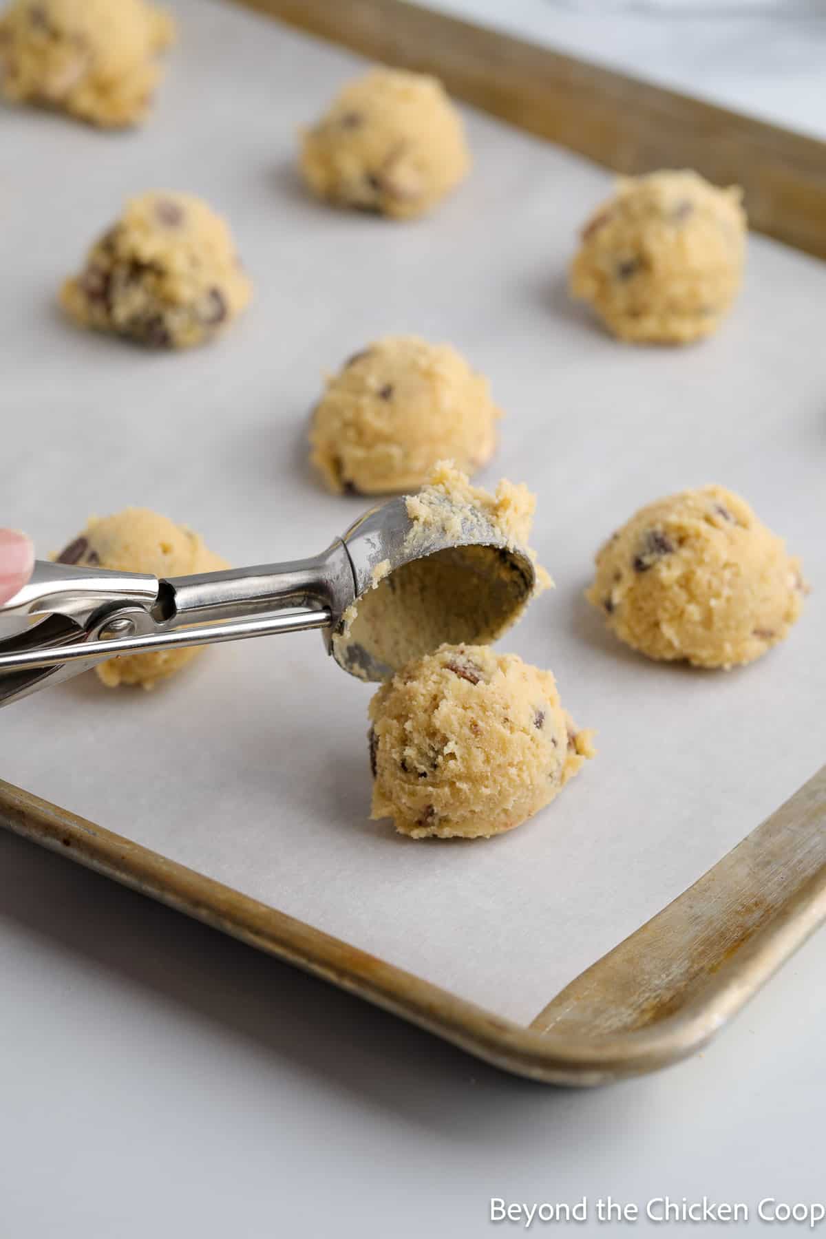 Scooping cookie dough onto a baking sheet.