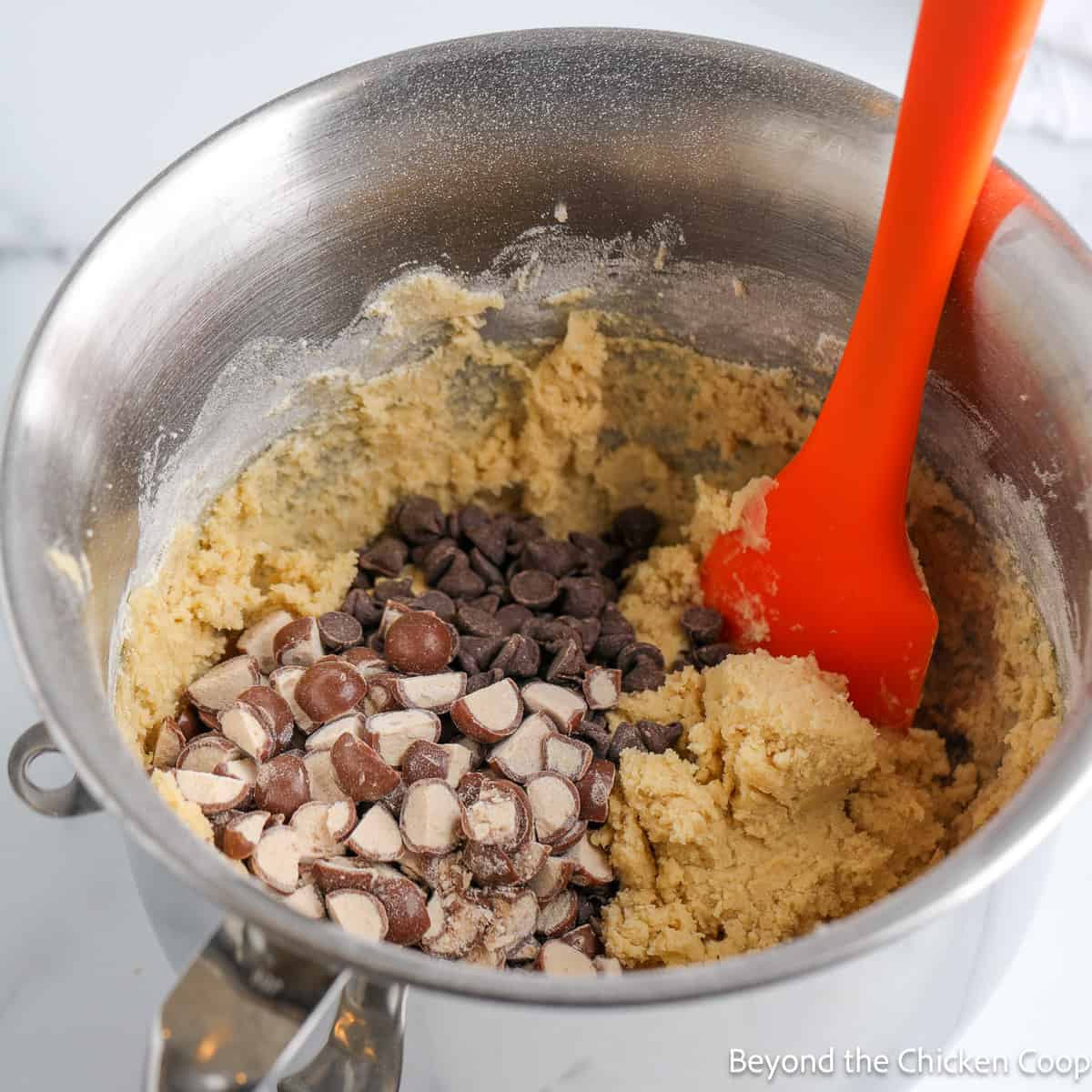 Cookie dough with whoppers in a mixing bowl. 