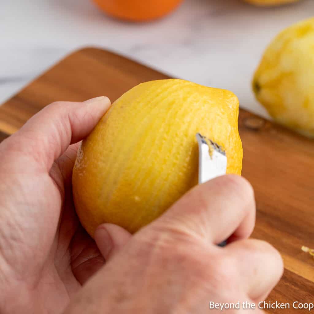 Using a citrus zester on a lemon. 
