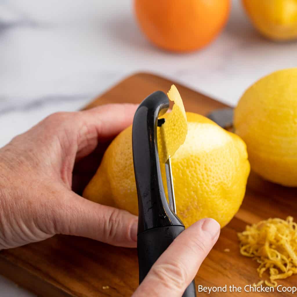 Peeling a lemon with a vegetable peeler. 