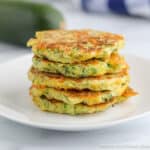 A stack of zucchini pancakes on a white plate.