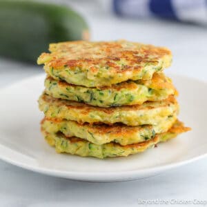 A stack of zucchini pancakes on a white plate.