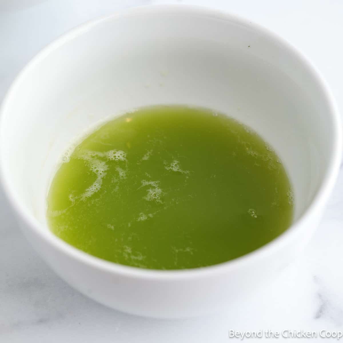 Green liquid in a white bowl. 
