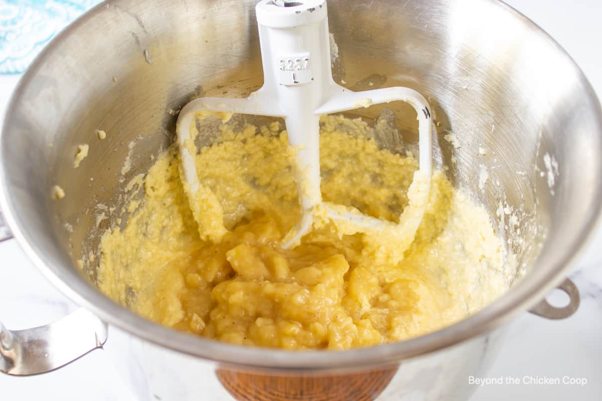 A mixing bowl filled with batter and mashed bananas.
