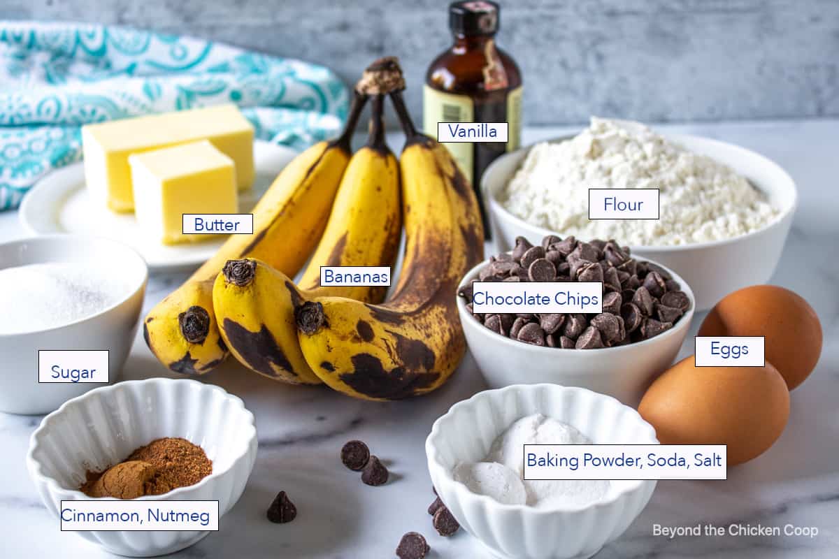 Ripe bananas in the center of small bowls filled with flour, sugar and other ingredients.