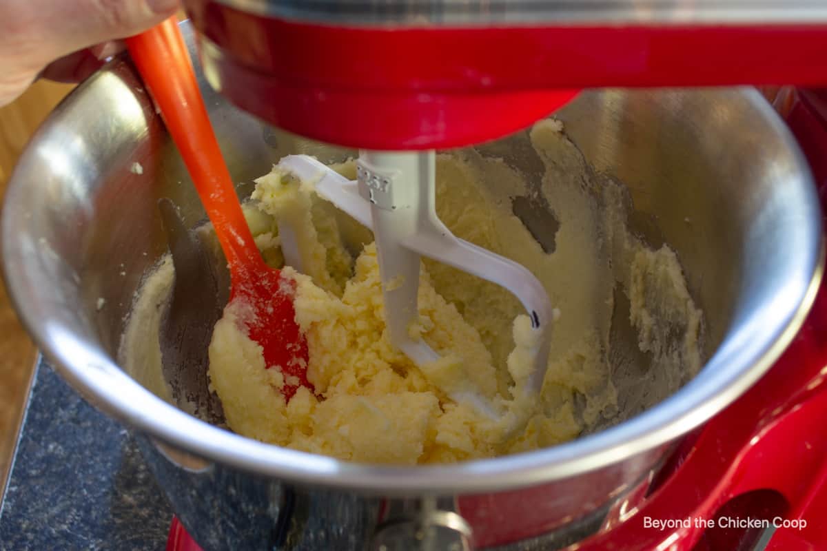 Scraping down the sides of a mixing bowl with a spatula.