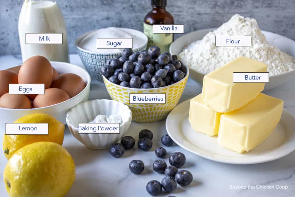 Ingredients for making a cake displayed on a marble surface.