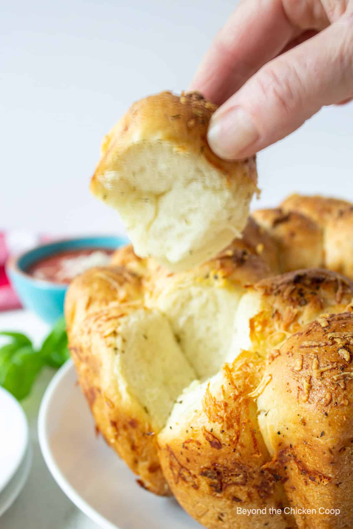 Garlic monkey bread being pulled apart from the loaf.