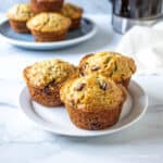 Three muffins on a small white plate.