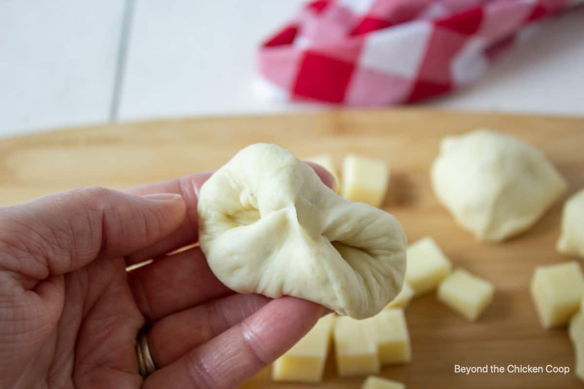 Bread dough being folded into a ball.