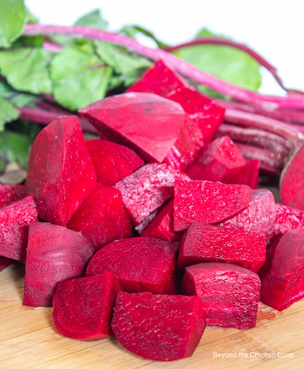 Chopped beets on a wooden cutting board.