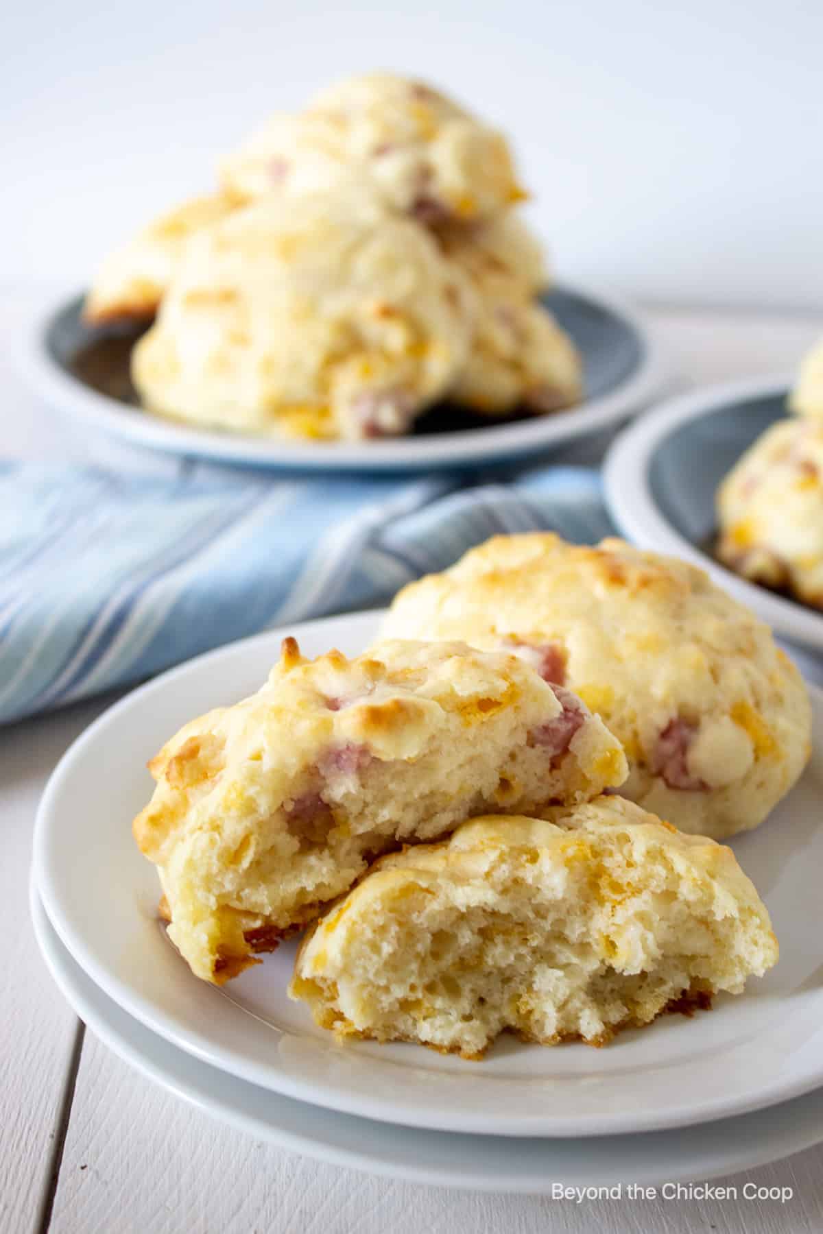 A drop biscuit with ham and cheese on a white plate.