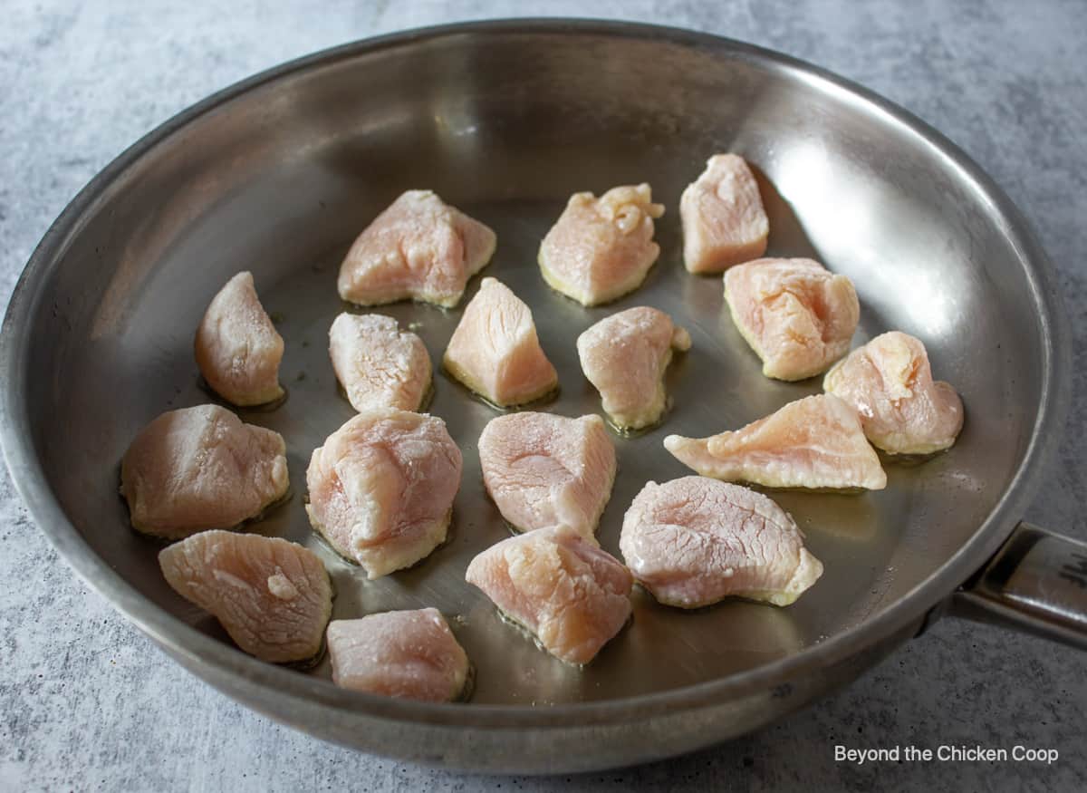 Chicken cooking in a frying pan.