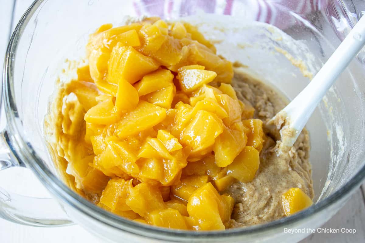 Chopped peaches in a large glass bowl.