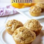 Three peach muffins on a white plate.