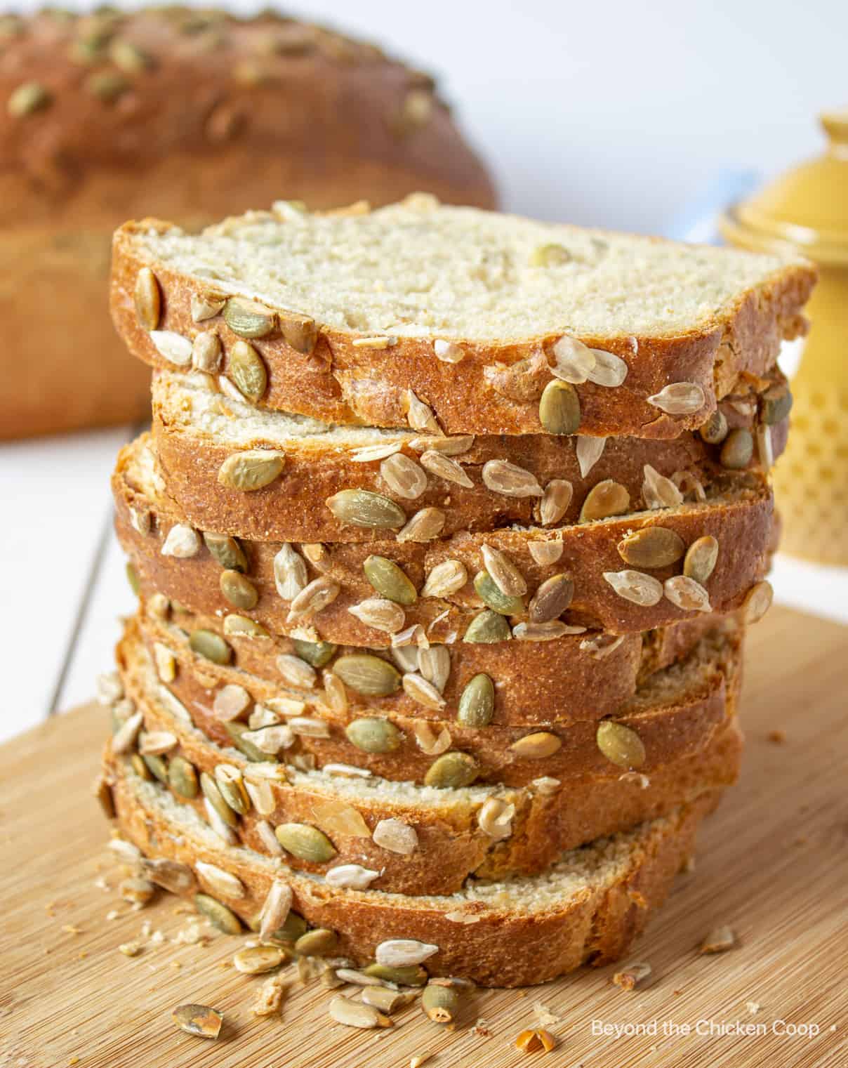 A stack of slice bread studded with pumpkin seeds.